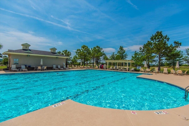 pool with a patio and fence