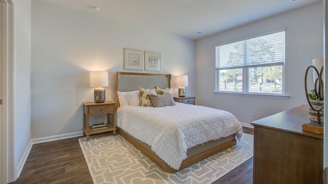 bedroom with dark wood-style flooring and baseboards