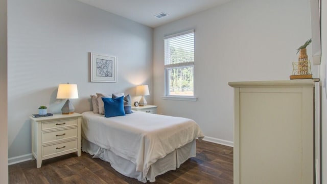 bedroom with dark wood-type flooring and baseboards