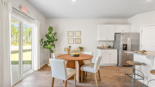 dining room featuring light wood finished floors and baseboards