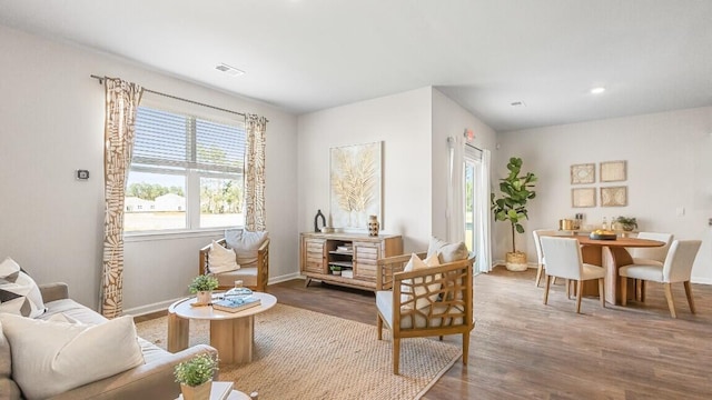 sitting room featuring healthy amount of natural light, wood finished floors, baseboards, and recessed lighting