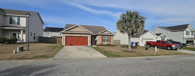 view of front of house with a garage, a residential view, driveway, and fence