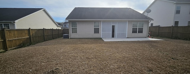 rear view of house featuring a fenced backyard and a patio