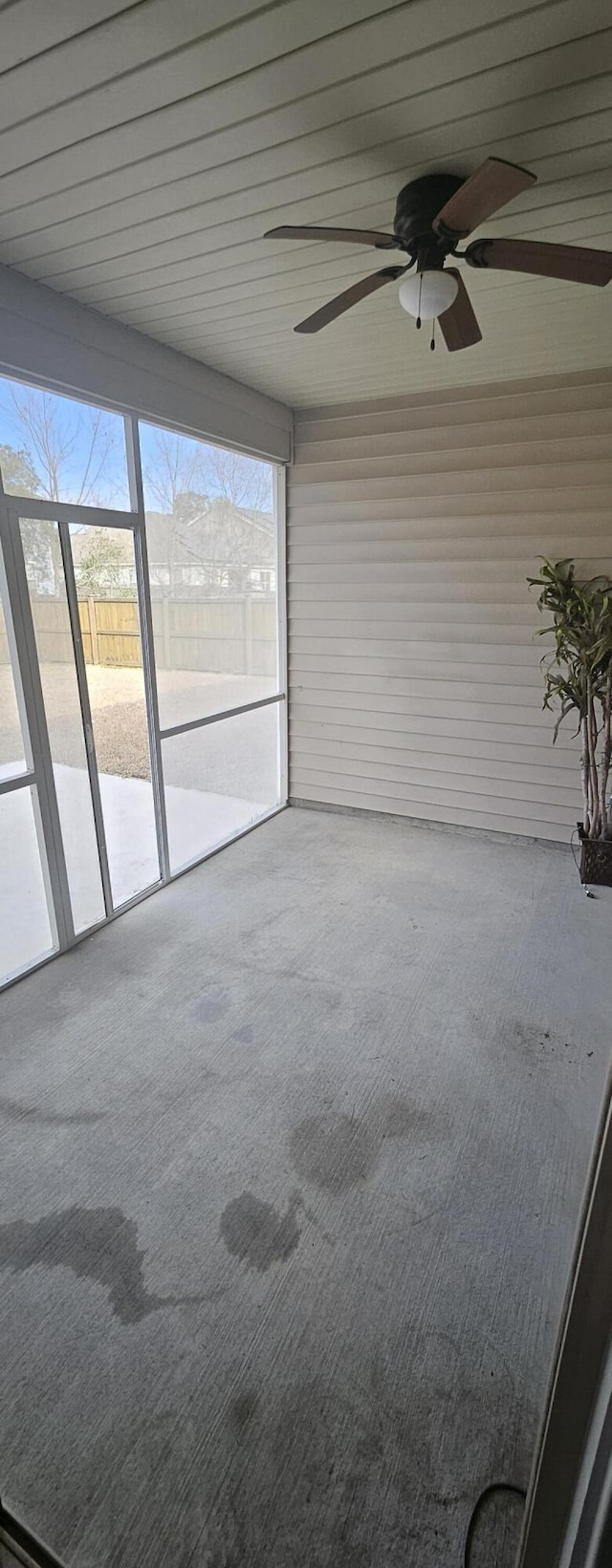 unfurnished sunroom with a ceiling fan