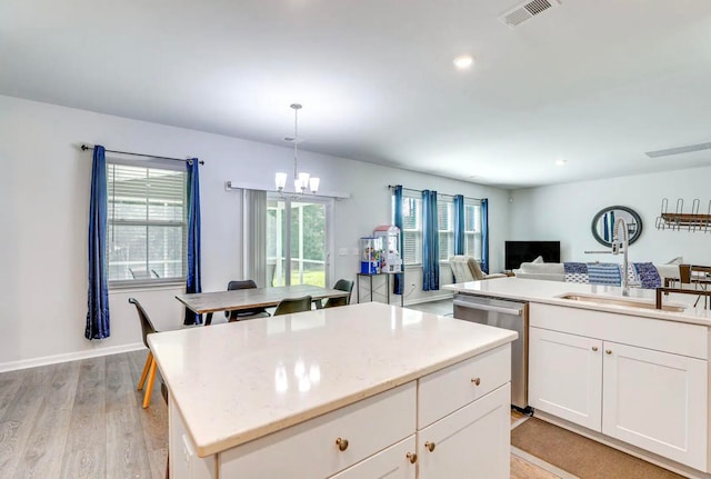 kitchen with light hardwood / wood-style floors, pendant lighting, sink, dishwasher, and a center island