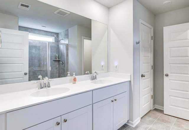 bathroom with vanity, a shower with door, and tile patterned floors