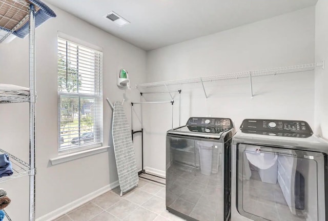 laundry room with light tile patterned flooring and washer and dryer