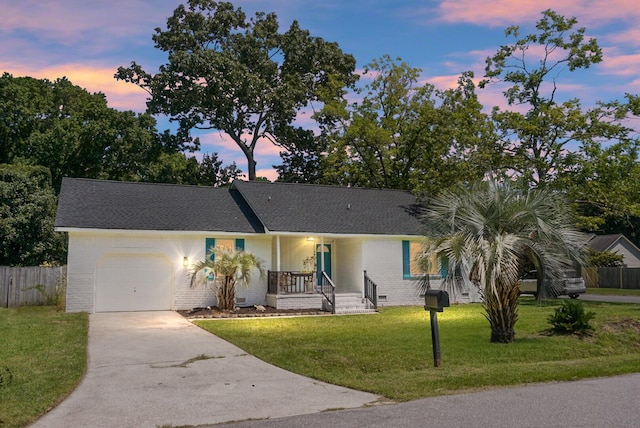 ranch-style house featuring an attached garage, crawl space, fence, driveway, and a front lawn