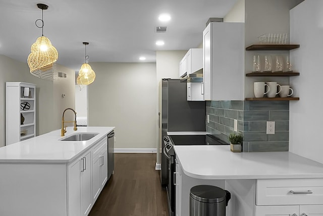 kitchen with tasteful backsplash, appliances with stainless steel finishes, dark wood-type flooring, a sink, and an island with sink