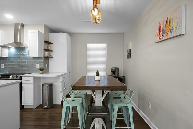 kitchen with visible vents, dark wood-style flooring, wall chimney range hood, open shelves, and backsplash