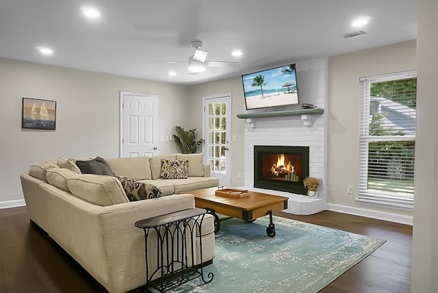 living area with dark wood finished floors, a fireplace, recessed lighting, visible vents, and baseboards