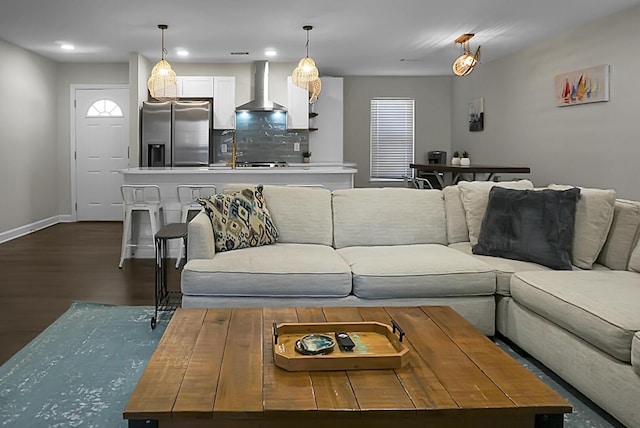 living area with dark wood-style floors, recessed lighting, and baseboards