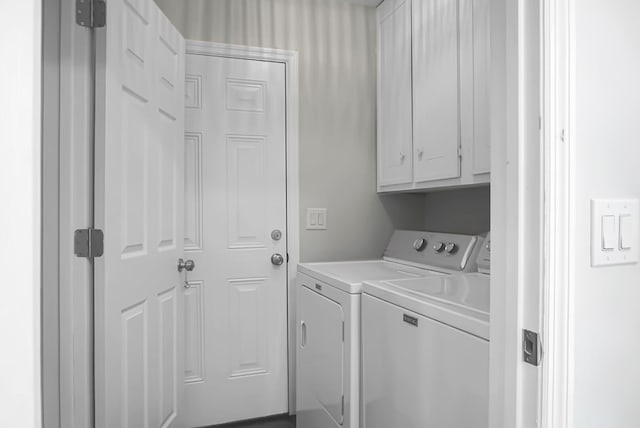 clothes washing area featuring cabinet space and washing machine and clothes dryer