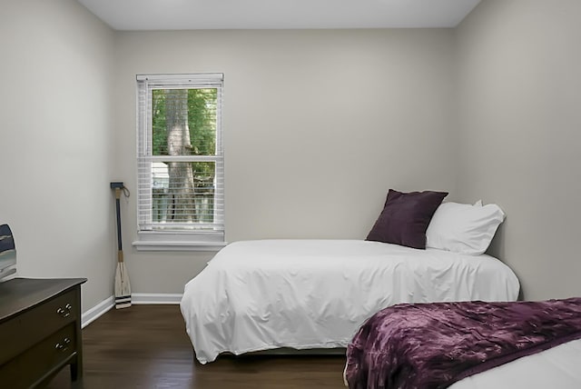 bedroom with dark wood finished floors and baseboards