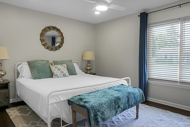 bedroom featuring wood finished floors, a ceiling fan, and baseboards