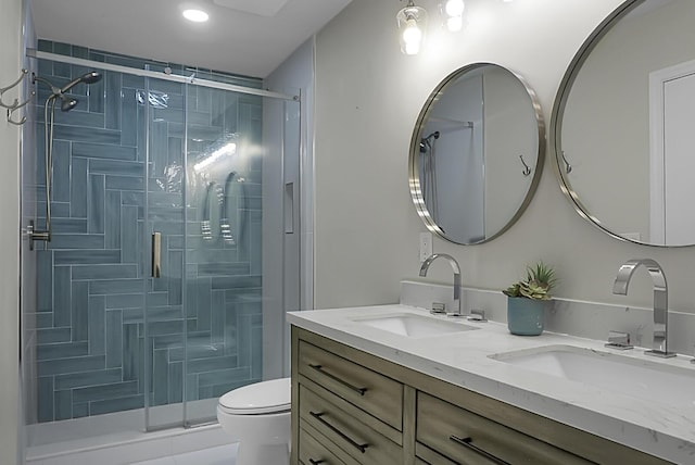 bathroom featuring a stall shower, a sink, toilet, and double vanity