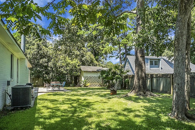 view of yard with central air condition unit, a fenced backyard, and a patio