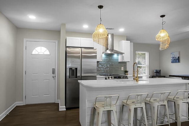 kitchen with a sink, wall chimney range hood, stainless steel refrigerator with ice dispenser, decorative backsplash, and dark wood finished floors