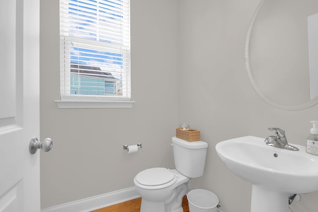 bathroom with hardwood / wood-style flooring, toilet, and sink