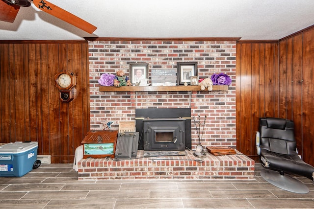 living room featuring ornamental molding, a textured ceiling, and wood walls