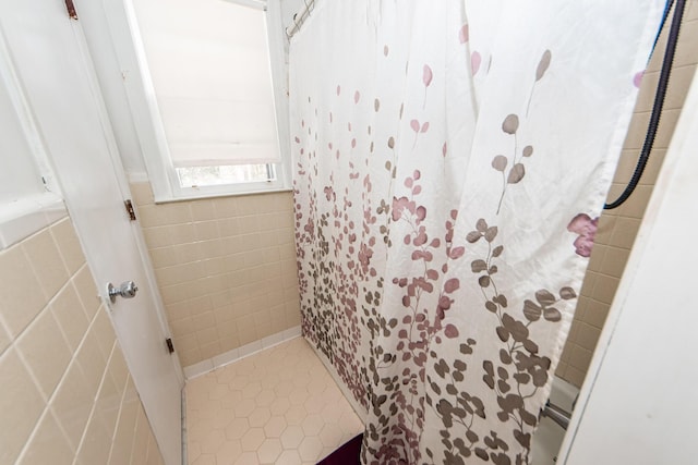 bathroom featuring tile walls, tile patterned flooring, and walk in shower