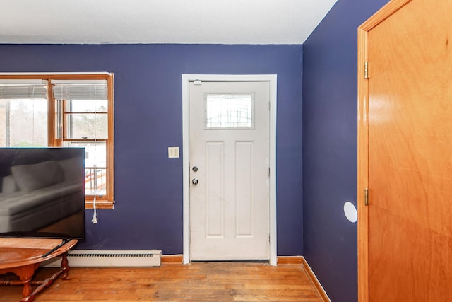 foyer entrance with hardwood / wood-style flooring, plenty of natural light, and baseboard heating