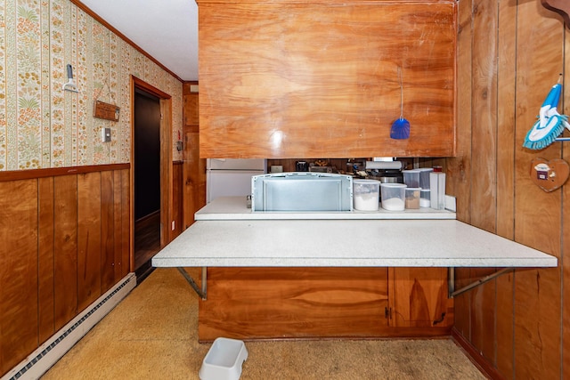 interior space with a baseboard radiator, ornamental molding, wooden walls, and white refrigerator