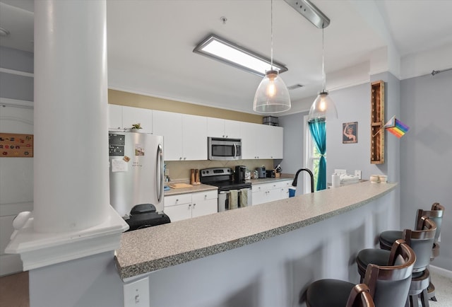 2632 Egret Crest Ln, Charleston, SC 29414 - kitchen featuring stainless steel appliances, a peninsula, a kitchen bar, backsplash, and white cabinetry