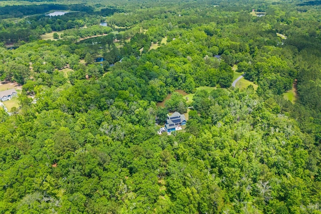 aerial view of property and surrounding area featuring a heavily wooded area