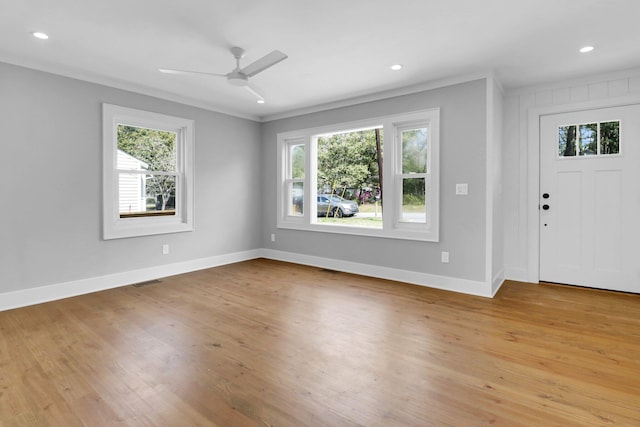 foyer featuring light hardwood / wood-style flooring, a wealth of natural light, ceiling fan, and crown molding