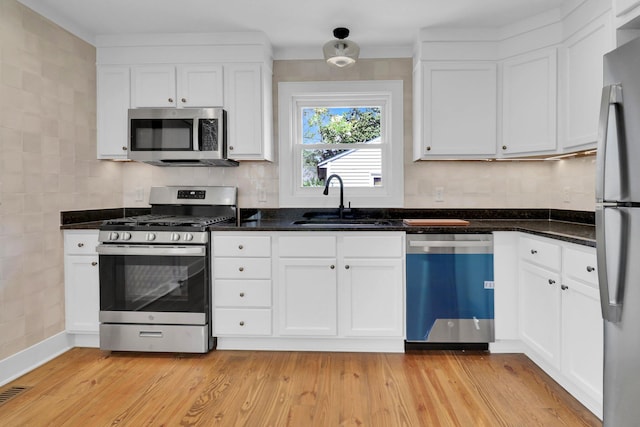 kitchen with white cabinets, appliances with stainless steel finishes, and light wood-type flooring