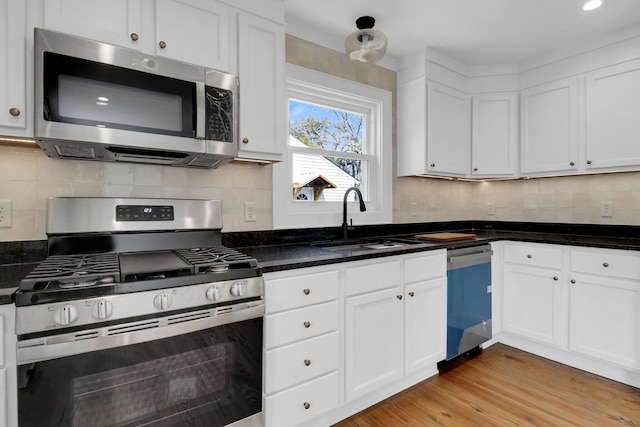 kitchen with stainless steel appliances, backsplash, light hardwood / wood-style flooring, and sink