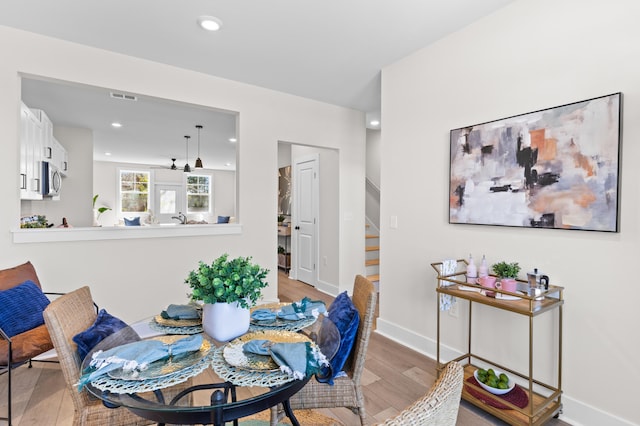 dining room with baseboards, visible vents, stairway, light wood-type flooring, and recessed lighting