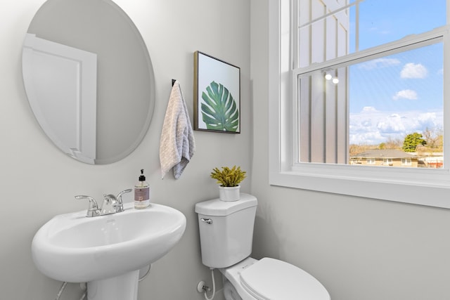 bathroom with a healthy amount of sunlight, toilet, and a sink