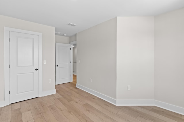 unfurnished bedroom featuring light wood-style flooring, visible vents, and baseboards