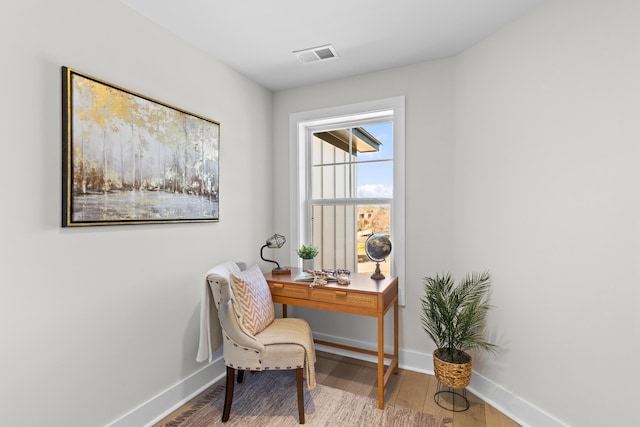 office area with baseboards, visible vents, and light wood finished floors