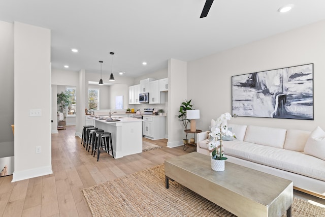 living room featuring light wood-style floors, recessed lighting, and baseboards