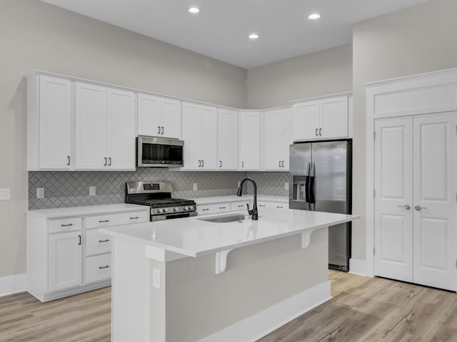 253 River Martin Ct, Summerville, SC 29483 - kitchen featuring an island with sink, a sink, light wood-style flooring, stainless steel appliances, and white cabinets