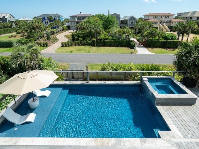 view of swimming pool with a pool with connected hot tub and a residential view
