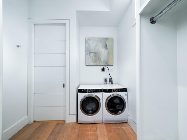 clothes washing area featuring laundry area, light wood-style flooring, and independent washer and dryer