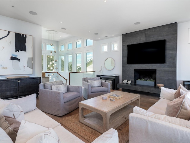 living area with a fireplace, recessed lighting, wood finished floors, and visible vents