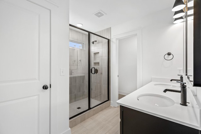 bathroom featuring tile patterned flooring, vanity, and an enclosed shower