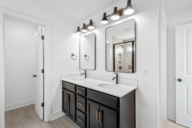 bathroom featuring hardwood / wood-style floors, vanity, and a shower with shower door