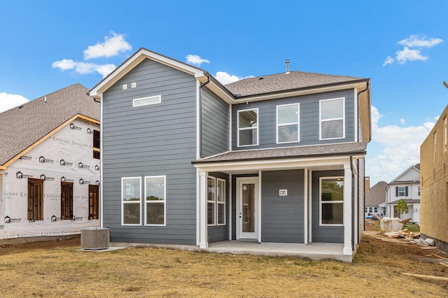 back of property featuring a lawn, central AC unit, and a patio