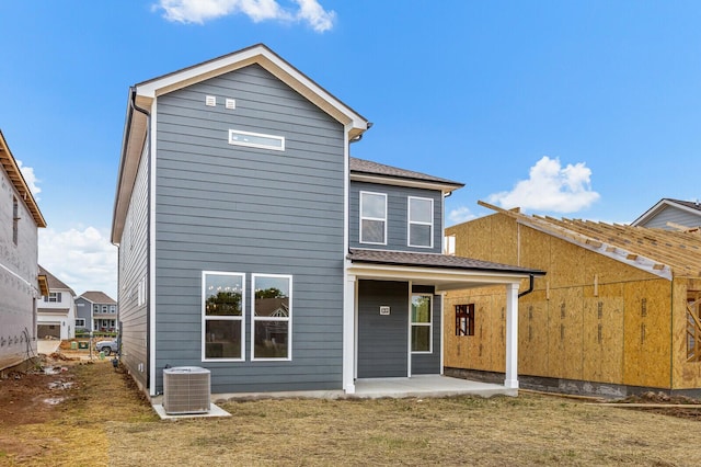 back of house with a patio area, central air condition unit, and a yard