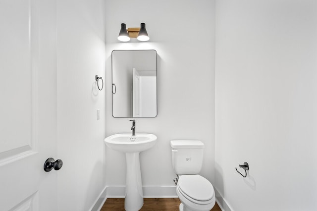 bathroom with toilet and wood-type flooring