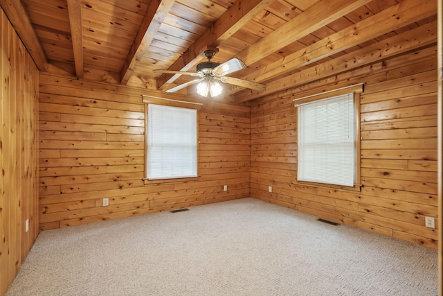 carpeted spare room with ceiling fan, wooden walls, beam ceiling, and wooden ceiling