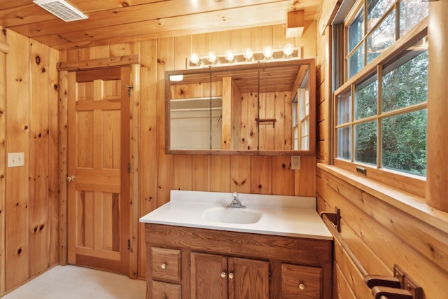 bathroom featuring vanity and wood walls