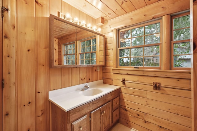 bathroom with wood ceiling, vanity, and wood walls