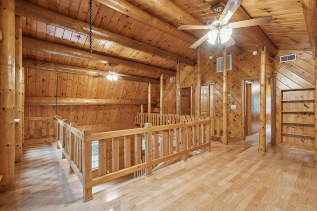 interior space featuring wood walls, light hardwood / wood-style flooring, wooden ceiling, ceiling fan, and beam ceiling